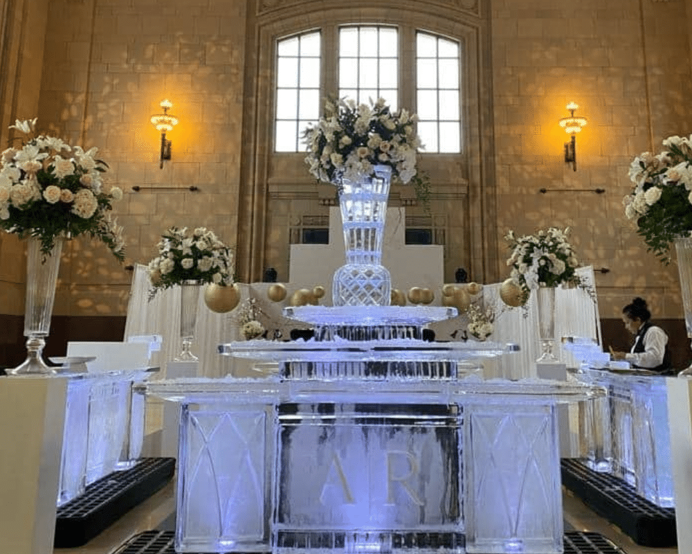 3 ice bars on display at Union Station in Kansas City. The bars are adorned with large vases filled with floral arrangements